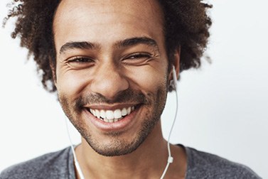 a man smiling and wearing headphones