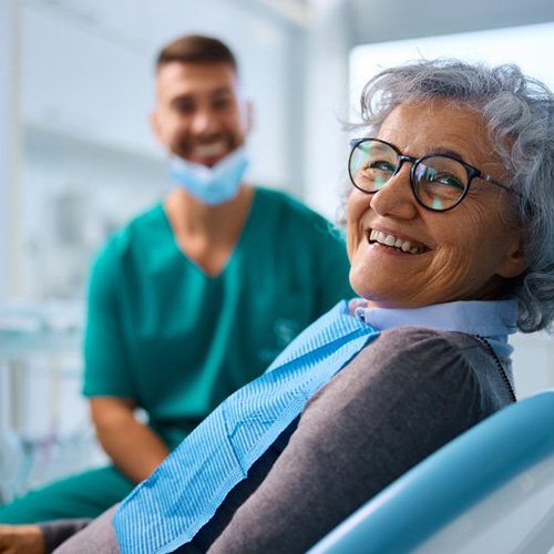 a patient smiling after getting her new dentures