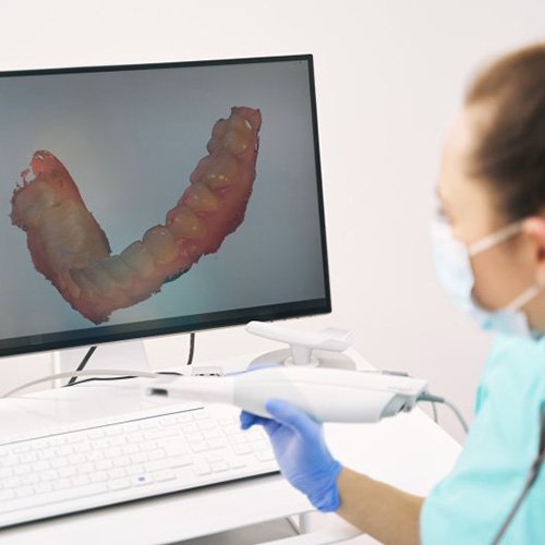 a dentist looking at a digital impression of teeth