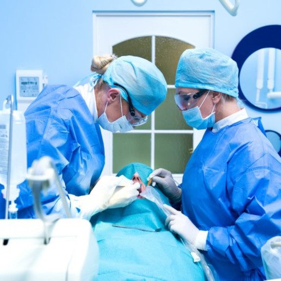 An oral surgeon performing dental implant placement